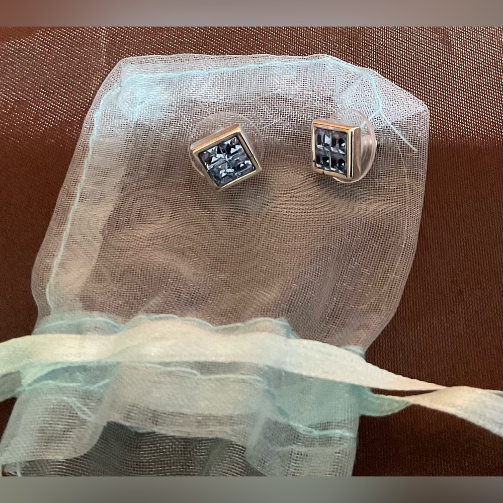 square stud earrings with blue gemstones set in a silver-toned metal frame